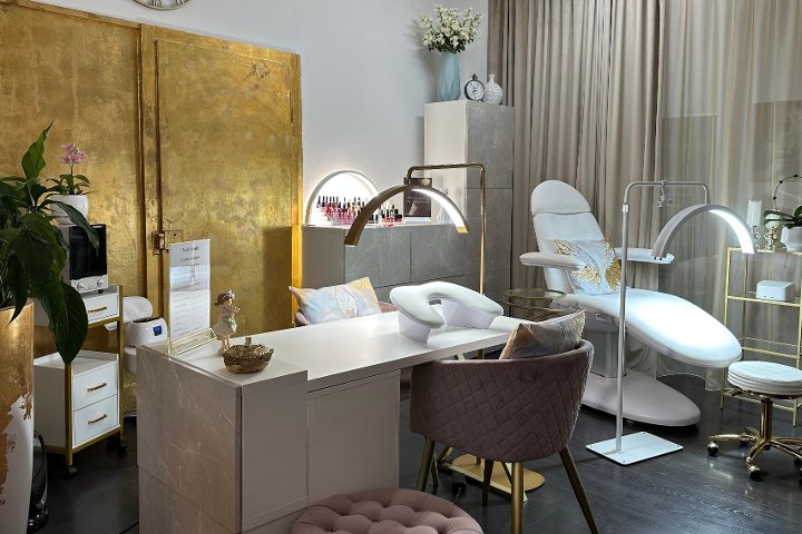 Arbeitsplatz mit Bogenlampen und Goldpaneel im Nailbloom Studio